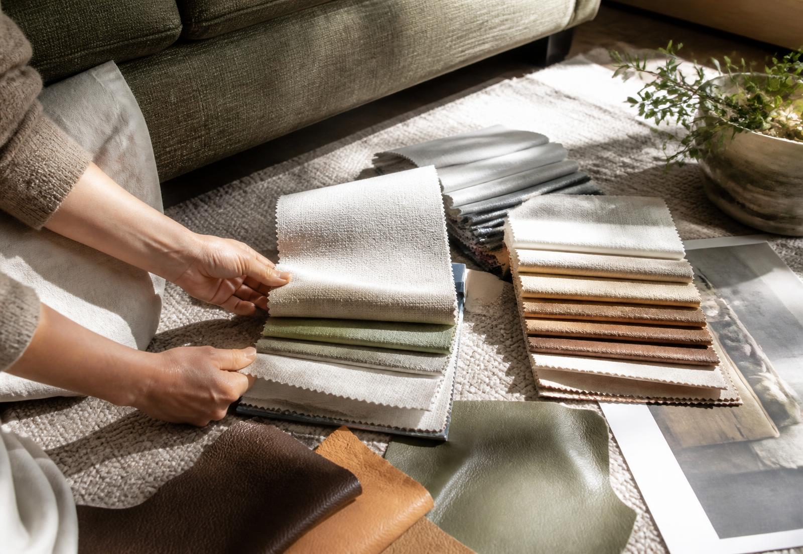 Fabric books and leather samples laid out and compared during a home showroom visit